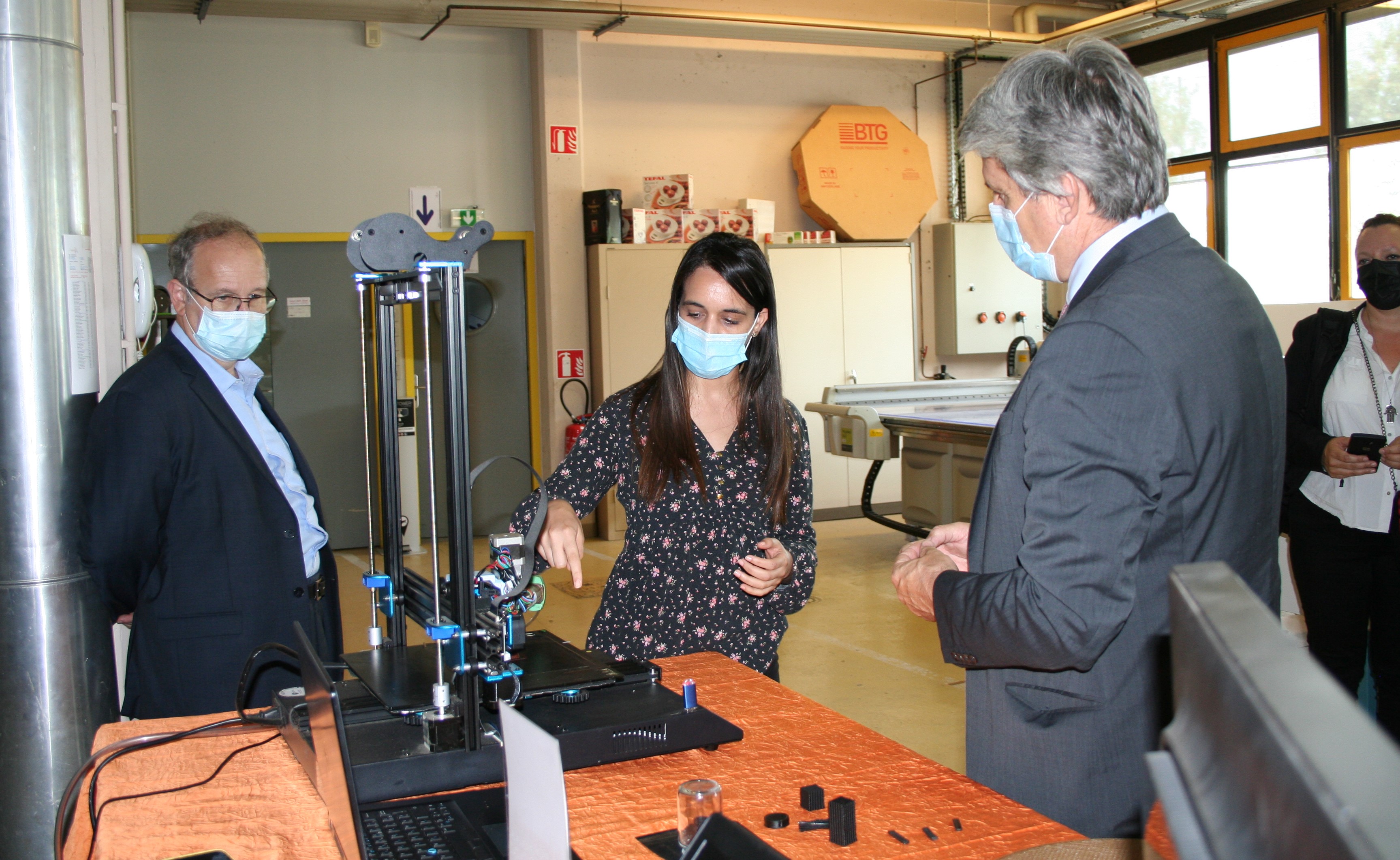 Une membre de l'équipe de Grenoble INP expliquant le fonctionnement d'une machine au recteur Fioni