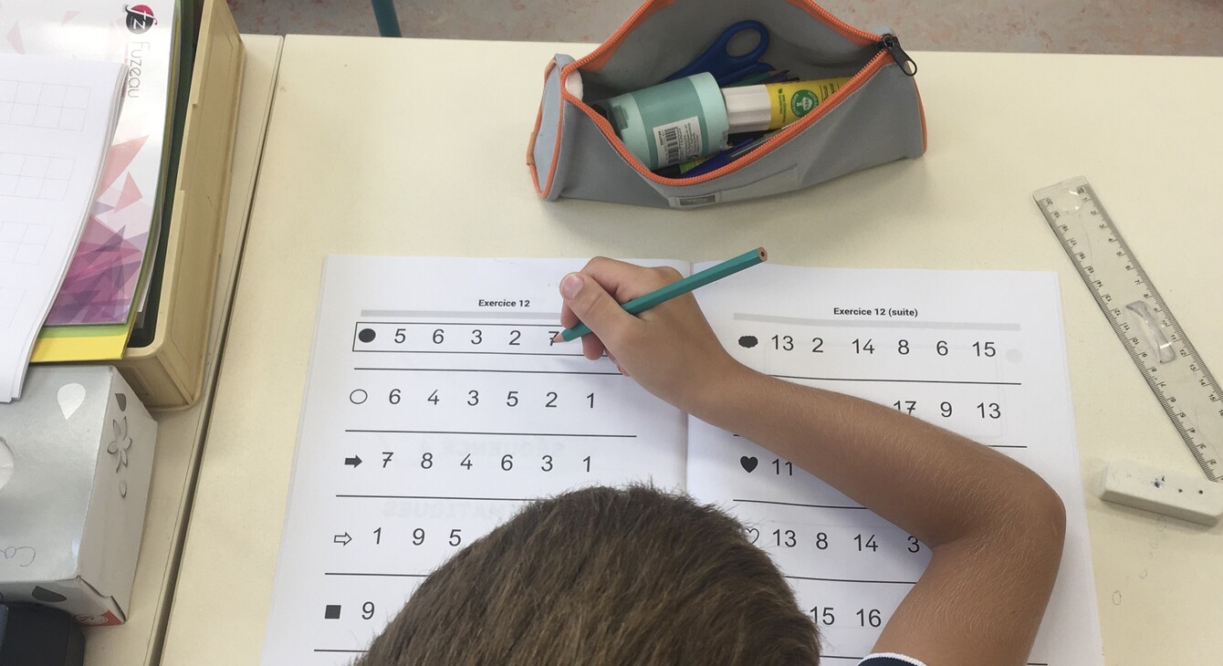 Jeune élève assis à son bureau