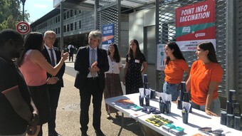 Le recteur Fioni à la rencontre des étudiantes en santé tenant un stand d'information sur la vaccination